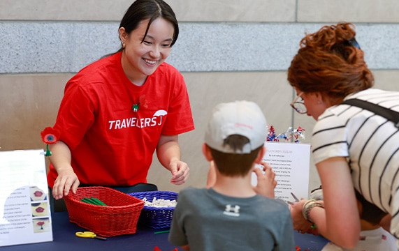 woman in red shirt at an exhibit table