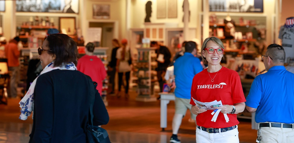 woman in red shirt smiling in museum gift shop